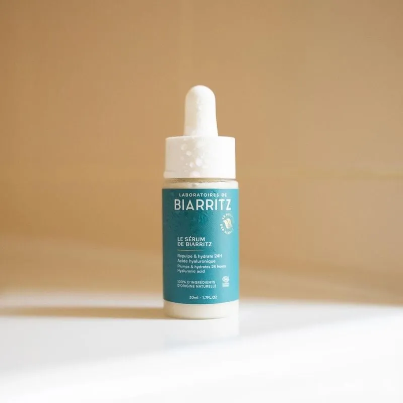 Ambient shot of Laboratoires de Biarritz 1733899 serum placed on a wooden surface with seashells, ev