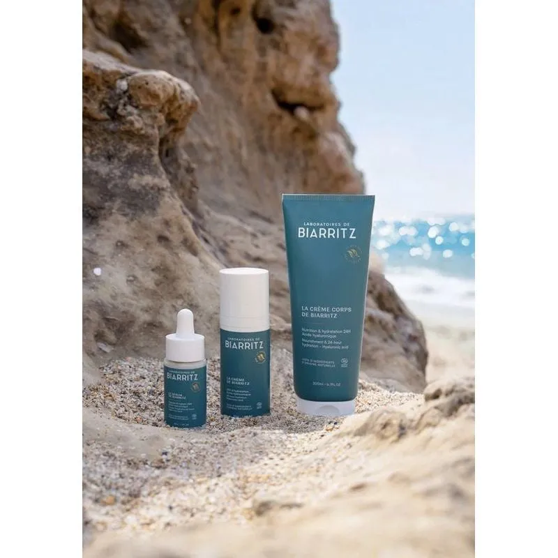 Ambient image of Laboratoires de Biarritz serum on a bamboo tray with green leaves, natural setting.